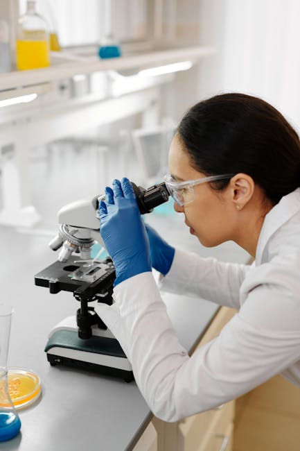 A focused scientist using a microscope in a modern laboratory, conducting important research.